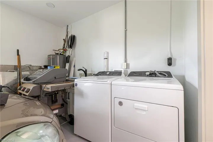 Laundry room with washing machine and clothes dryer and water heater