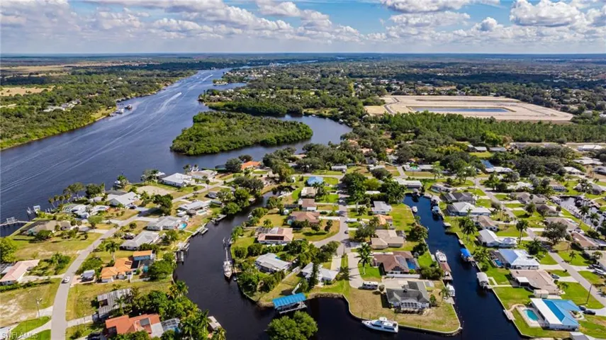 Aerial view of property's location with a large body of water and nearby suburban area