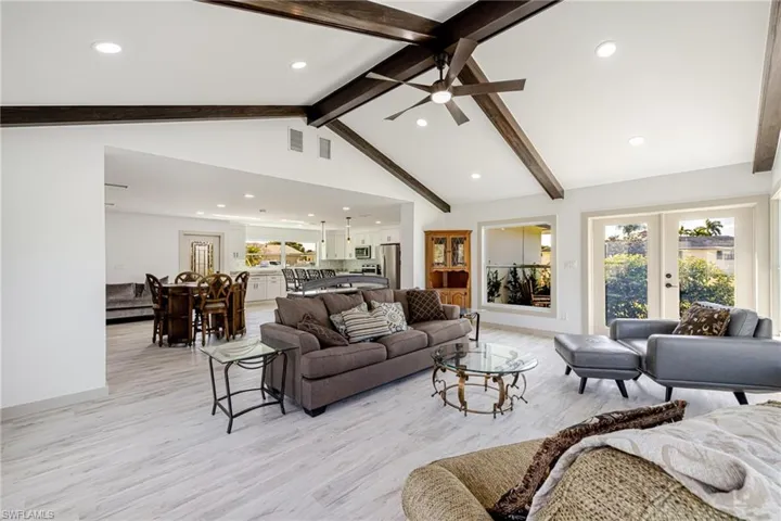 Living area featuring recessed lighting, light wood finished floors, french doors, high vaulted ceiling, and beamed ceiling
