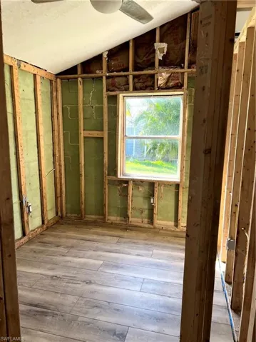Miscellaneous room with vaulted ceiling and light wood-type flooring