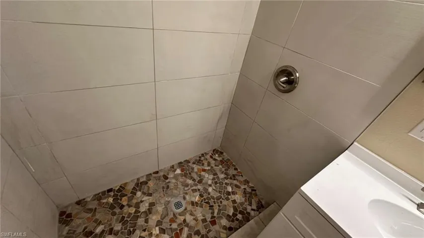 Bathroom featuring a tile shower and sink