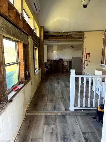 Hallway with dark hardwood / wood-style floors and a wall mounted AC