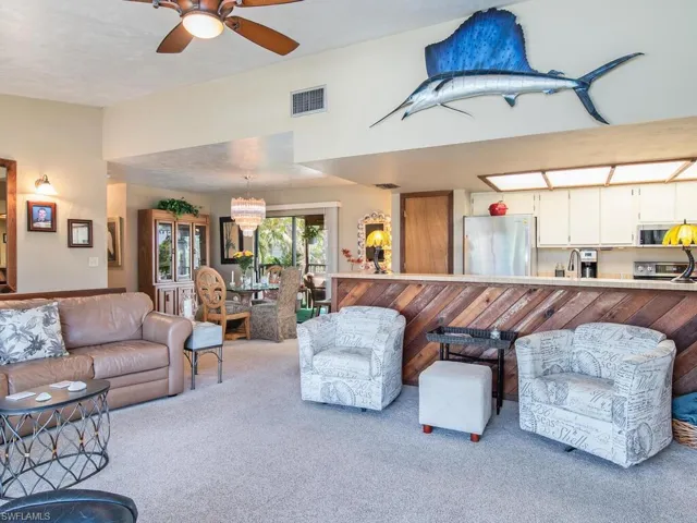 Carpeted living room with ceiling fan