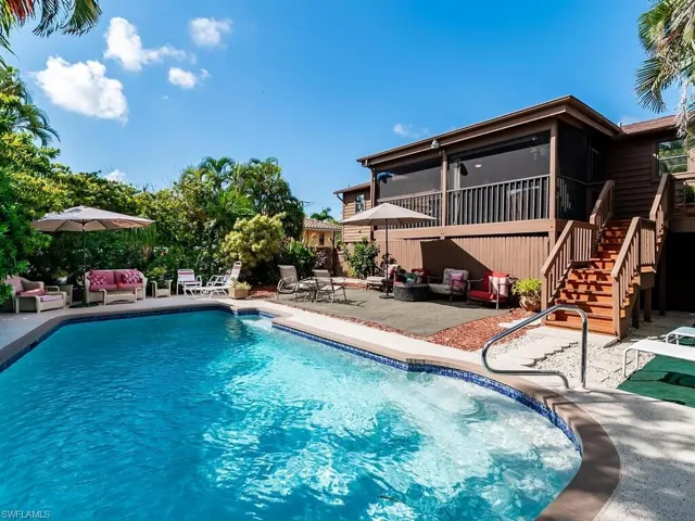 View of swimming pool with a patio and a sunroom