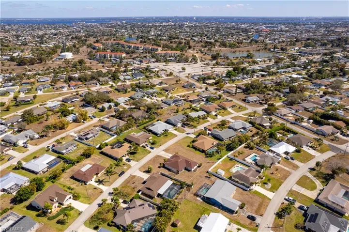 Aerial view of property and surrounding area with nearby suburban area and a nearby body of water