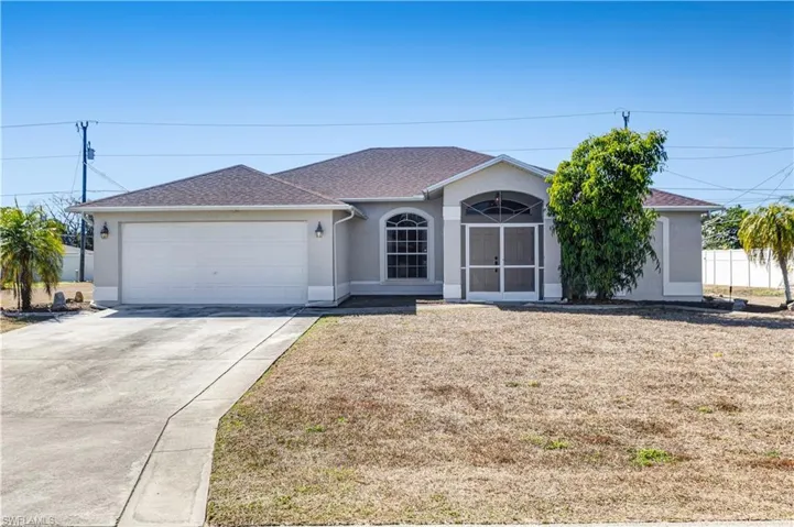 Ranch-style house featuring stucco siding, driveway, a shingled roof, an attached garage, and a front lawn