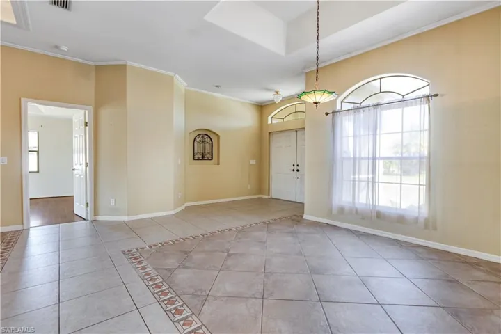 Tiled entrance foyer featuring baseboards and ornamental molding