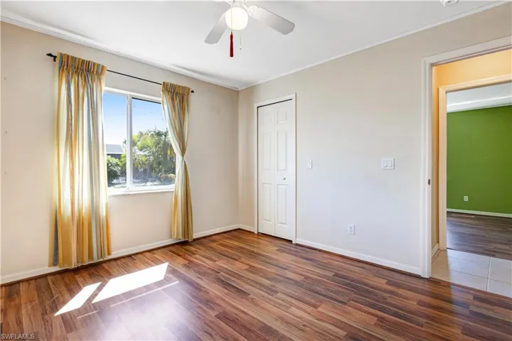 Unfurnished bedroom with wood finished floors, ceiling fan, and a closet