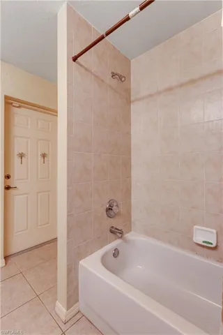 Full bathroom featuring shower / washtub combination, tile patterned floors, and a textured ceiling