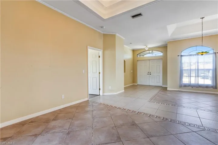 Entryway featuring ornamental molding and light tile patterned floors