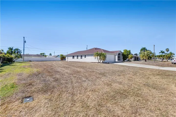 View of yard featuring concrete driveway and a garage