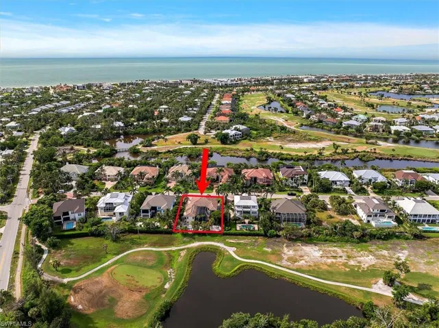 Aerial perspective of suburban area with a large body of water, property parcel outlined, and a local golf course