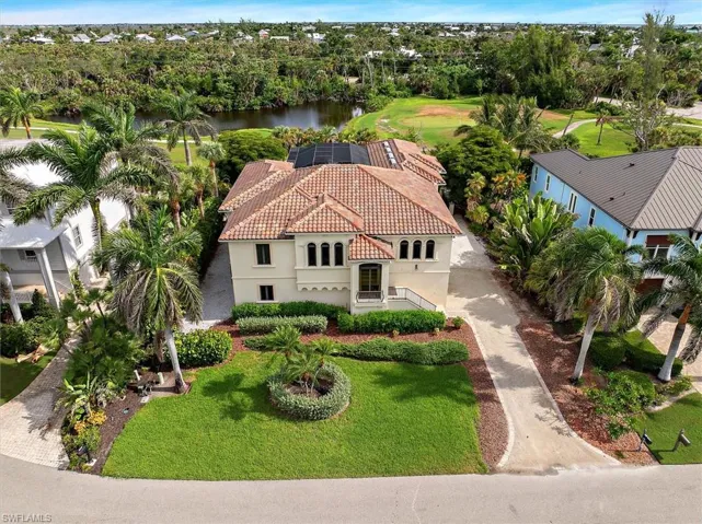 Aerial view of property and surrounding area featuring a tree filled landscape and a large body of water