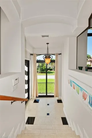 Entryway featuring plenty of natural light, tile patterned floors, and a chandelier