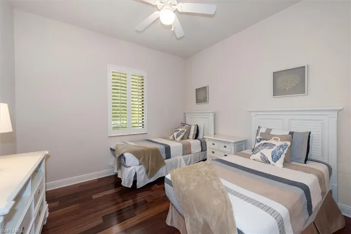 Bedroom with dark wood-type flooring and a ceiling fan