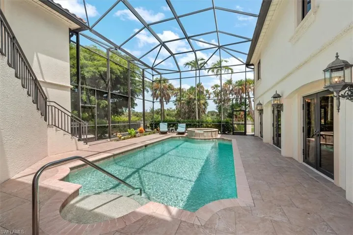 View of pool featuring a patio area, a sunroom, a lanai, and a pool with connected hot tub