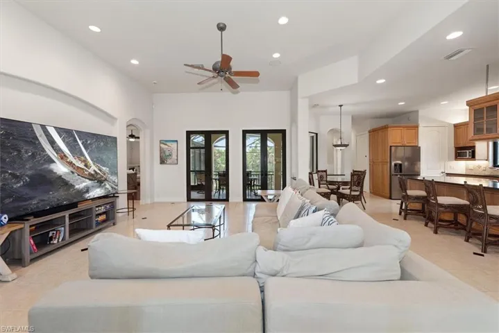 Living room with recessed lighting, light tile patterned floors, and ceiling fan