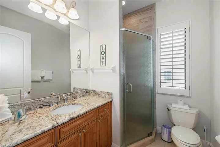 Full bathroom with vanity, a stall shower, and light tile patterned floors
