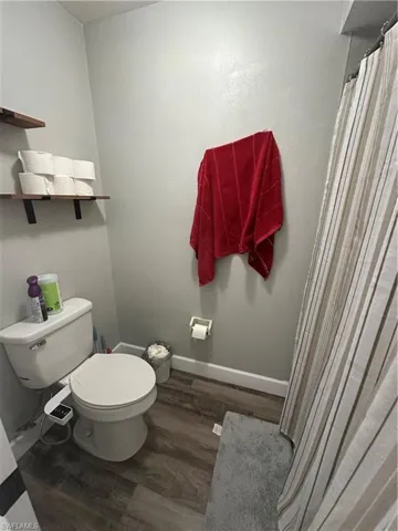 Bathroom featuring a shower with curtain and dark wood finished floors