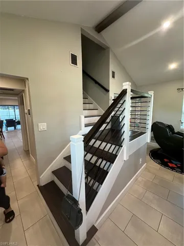 Stairs with tile patterned flooring and baseboards