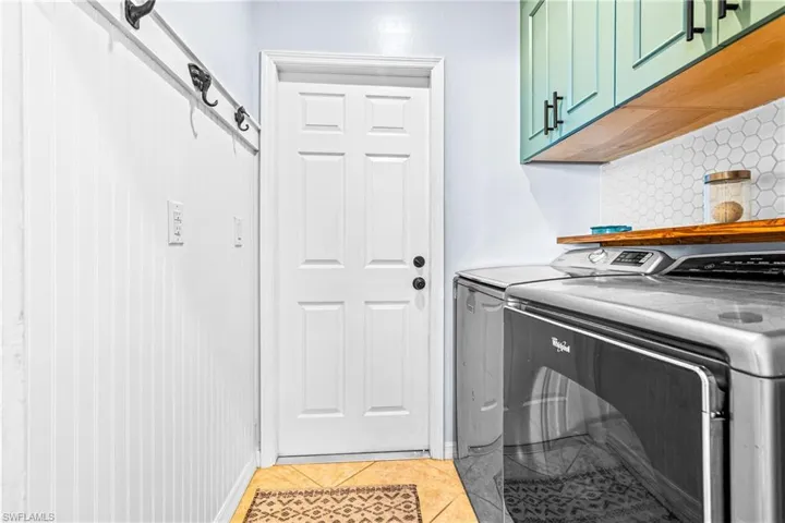 Laundry room with light tile patterned floors and independent washer and dryer