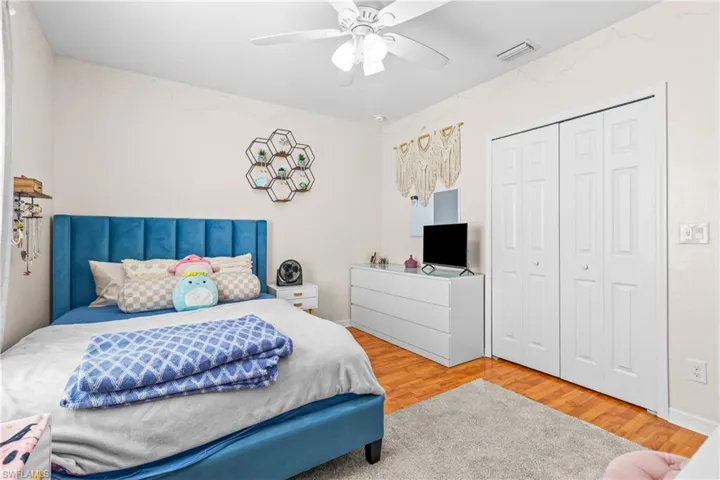 Bedroom featuring light wood finished floors, a closet, and ceiling fan
