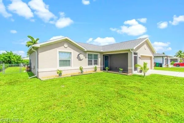 Ranch-style house featuring driveway, a front yard, a garage, and stucco siding