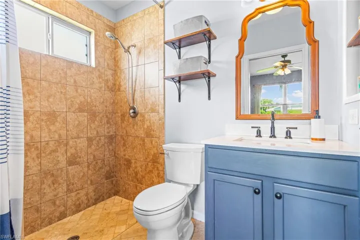 Full bathroom featuring plenty of natural light, a shower stall, vanity, and light tile patterned flooring