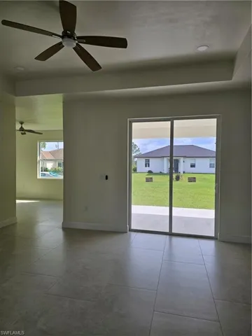 Tiled spare room featuring ceiling fan