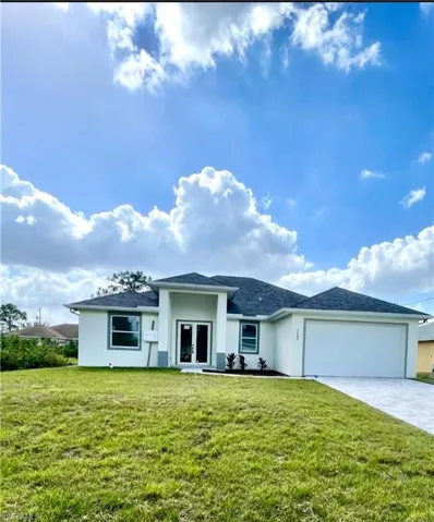 View of front of property featuring a front lawn, a garage, and french doors