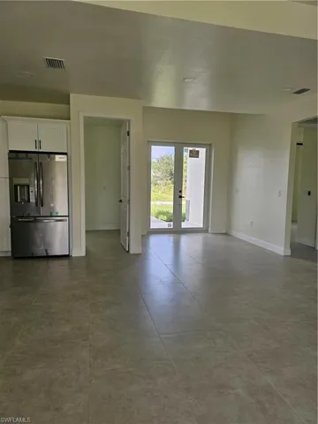 Unfurnished living room featuring french doors