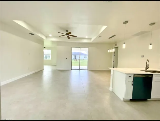 Kitchen featuring white cabinets, hanging light fixtures, sink, and black dishwasher