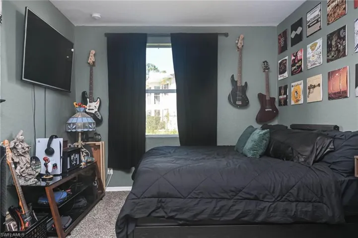 Bedroom featuring carpet floors and a textured wall
