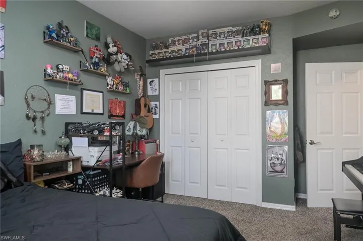 Bedroom featuring carpet, a closet, and an office area