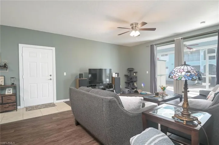 Living area with ceiling fan and wood finished floors
