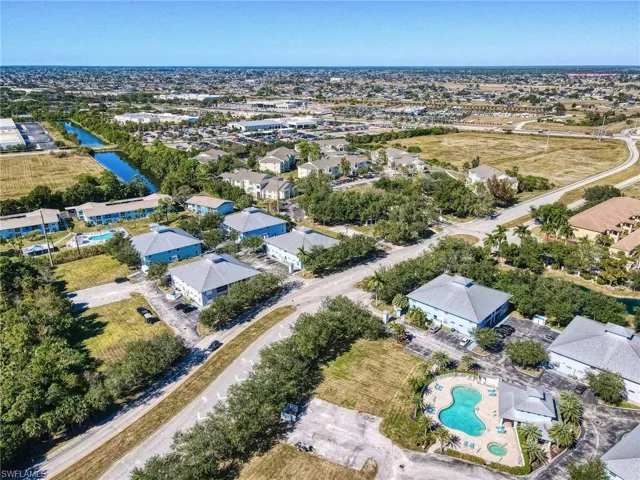 Aerial perspective of suburban area with a pool and a nearby body of water