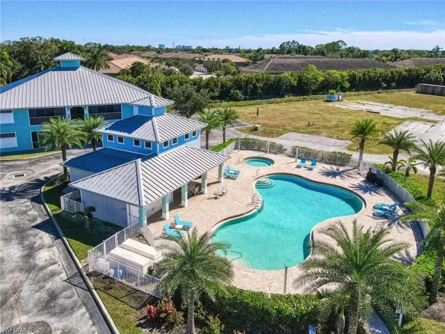 Community pool with a patio area and a hot tub