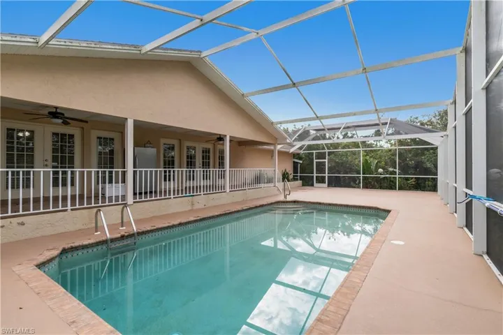 View of pool with a lanai, a patio, and ceiling fan