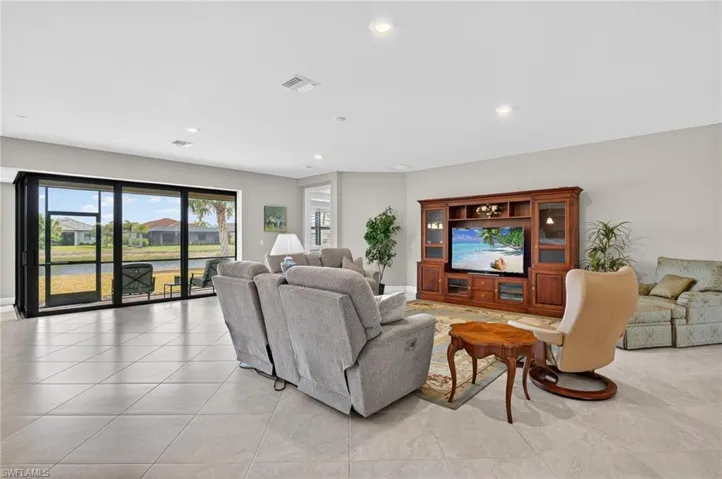 Living room featuring recessed lighting, a residential view, and light tile patterned floors