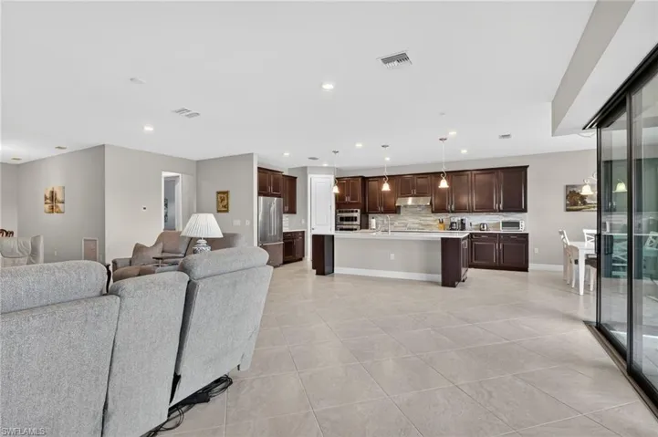 Living room with light tile patterned floors and recessed lighting