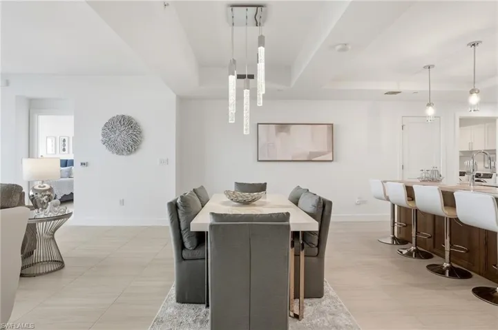 Dining space with a tray ceiling and elegant chandeliers  - Virtually Edited Image