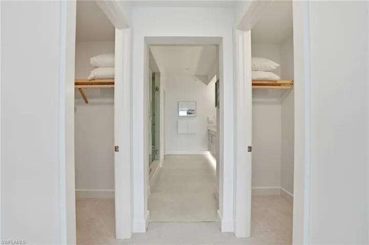 a view of both closets and primary bathroom Virtually Edited Image