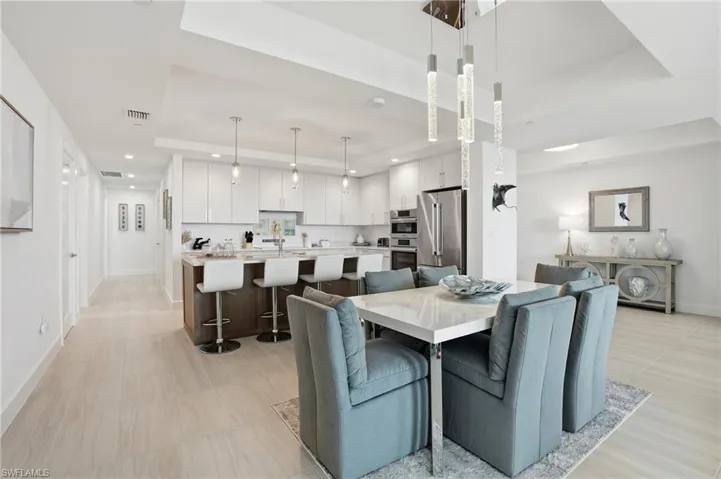 Dining area with a raised ceiling and recessed lighting - Virtually Edited Image