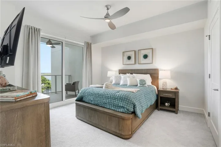Bedroom with light carpet, access to outside, and ceiling fan - Virtually Edited Image