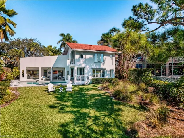 Back of house featuring an outdoor pool, a patio, stucco siding, a yard, and a tiled roof