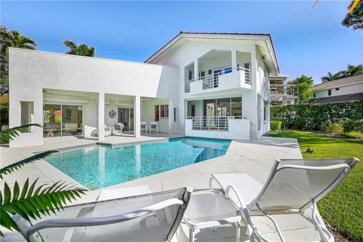 Rear view of property with a patio area, stucco siding, and a balcony