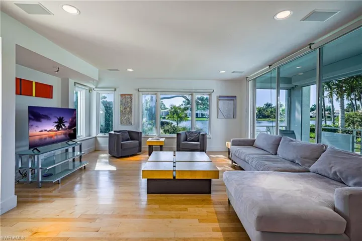 Living area featuring light wood finished floors, healthy amount of natural light, a water view, and recessed lighting