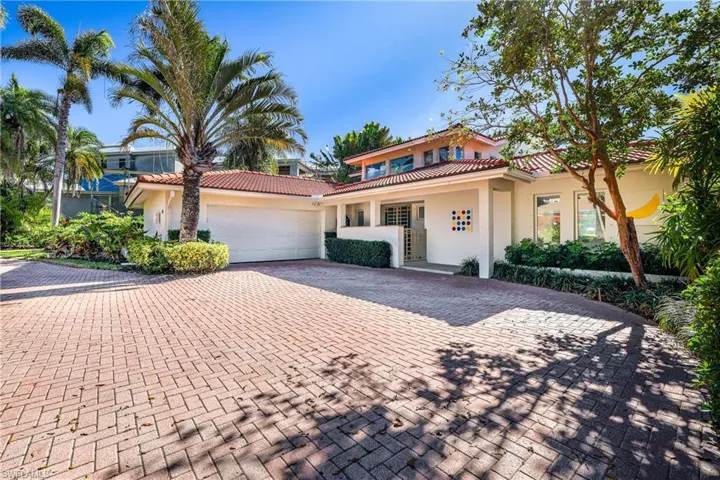 Mediterranean / spanish home featuring stucco siding, decorative driveway, a tile roof, and an attached garage