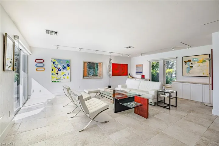 Living area with track lighting, plenty of natural light, and light tile patterned floors