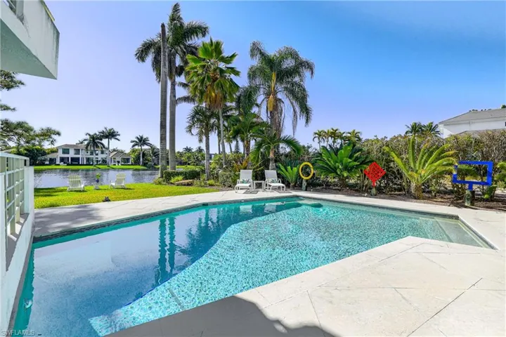 Swimming pool with a patio and a water view